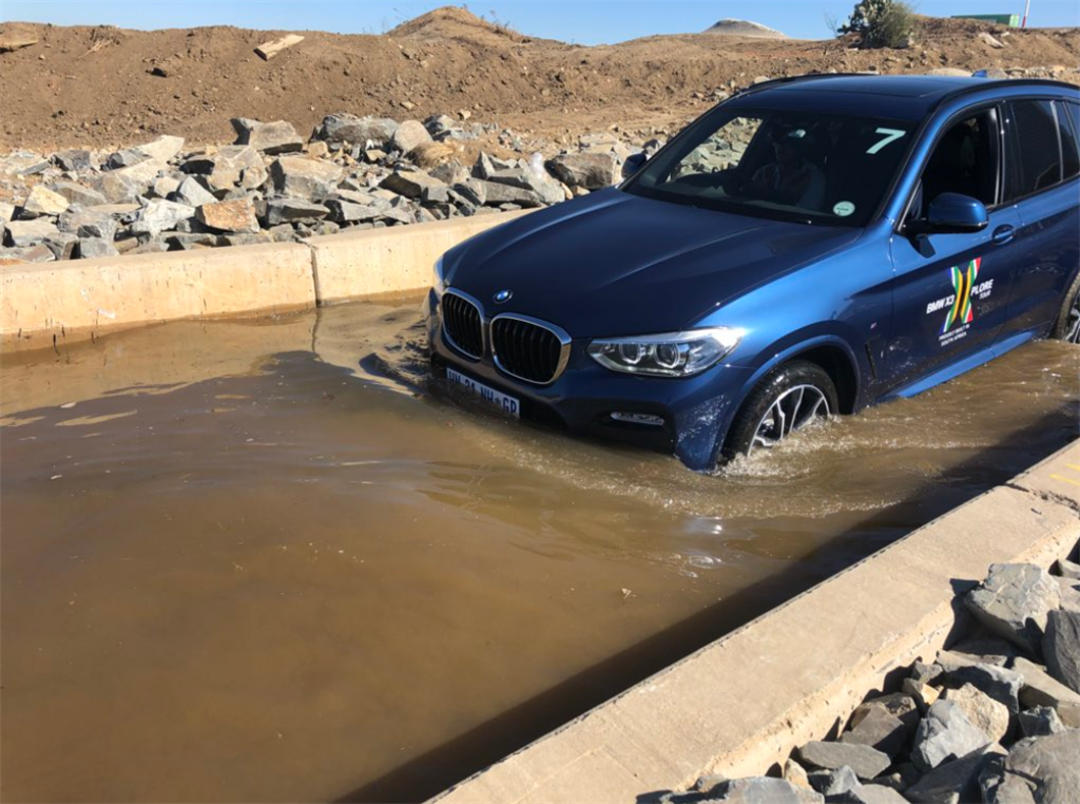 A BMW X3 tacking a water crossing